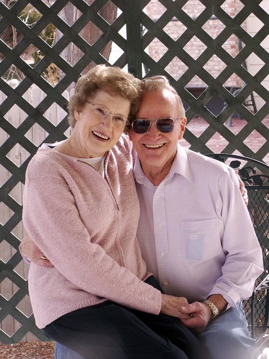 John and Melinda, the owners of J&M's Plants. Melinda is sitting on John's lap, smiling, while John wears sunglasses.